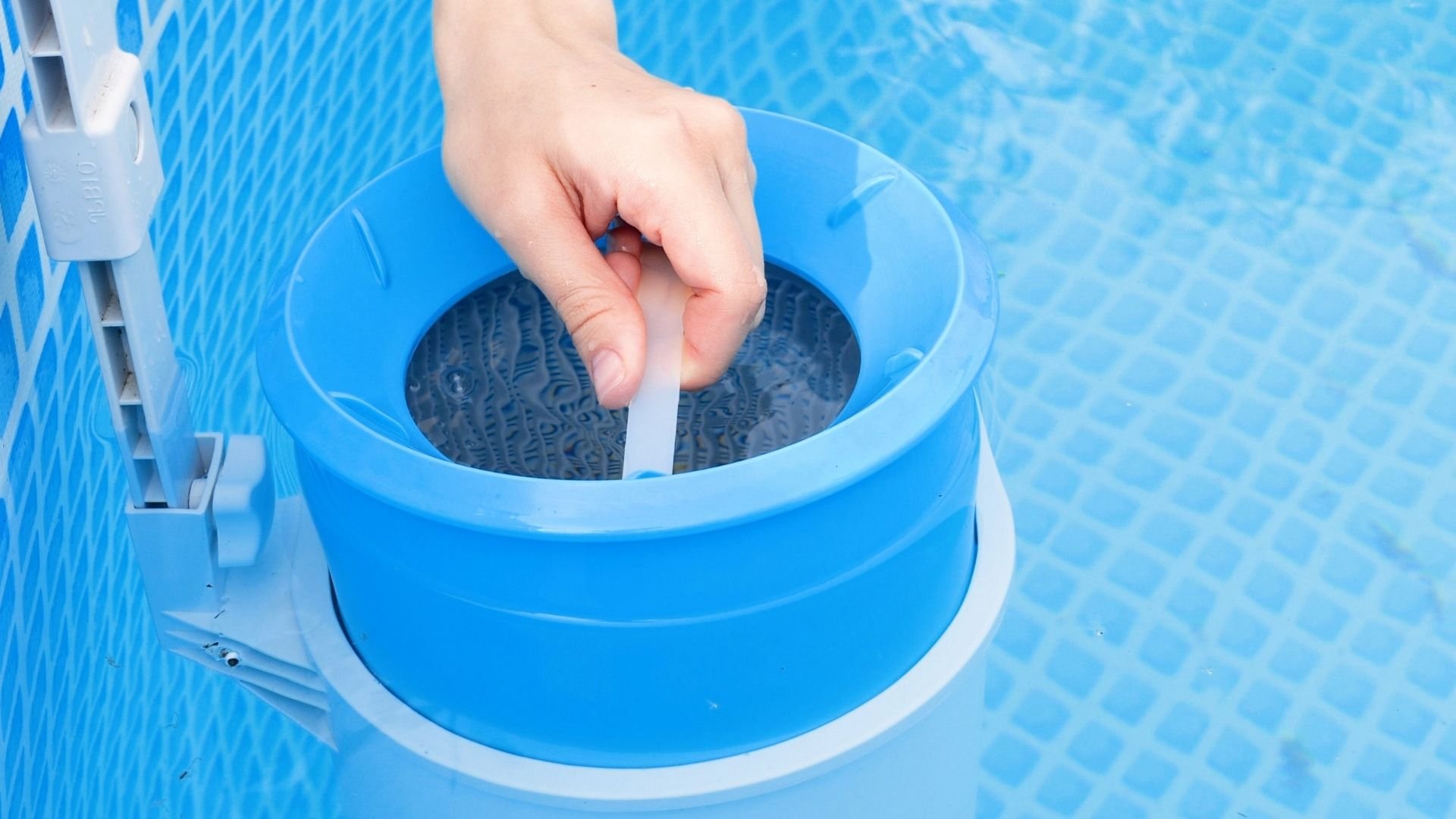 Hand testing pool water with test strip from blue chemical testing device