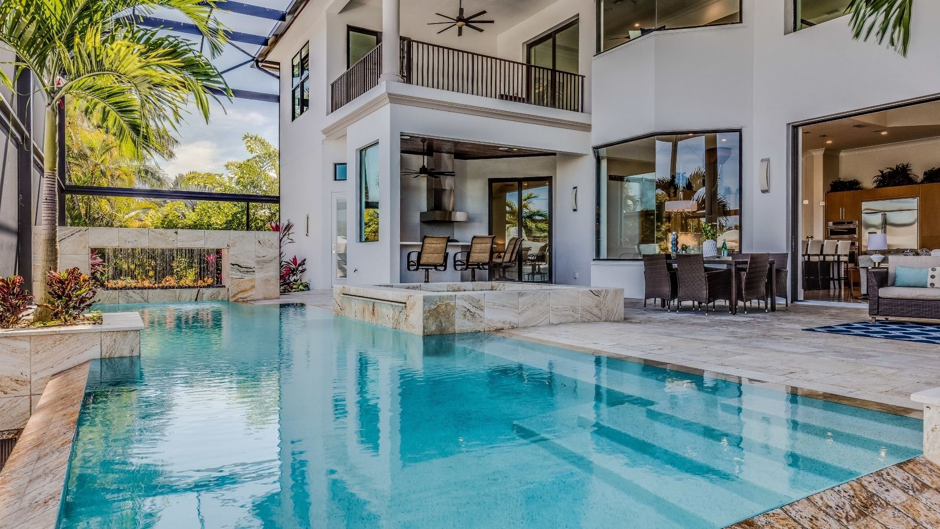 Modern luxury home with turquoise swimming pool and tropical landscaping overlooking ocean.